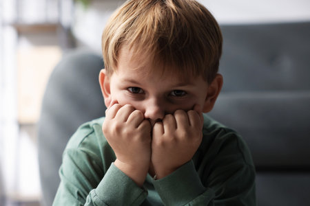Child in danger. Frightened little boy at homeの写真素材