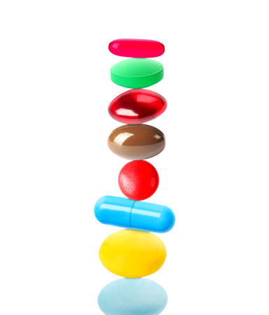 Different pills stacked on each other against white background