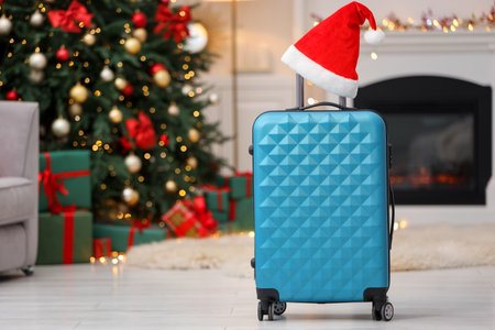 Christmas vacation. Suitcase with Santa hat indoors. Space for textの写真素材