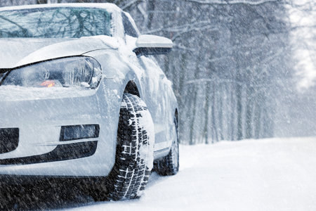 Car on snowy country road, closeup. Adverse weather conditionsの写真素材