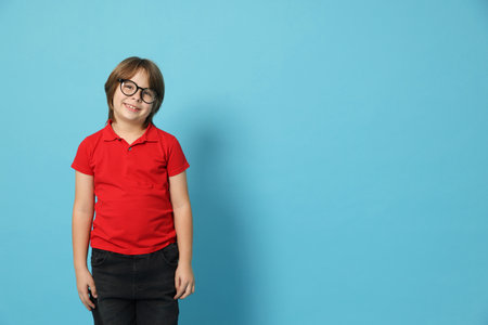 Boy with glasses on light blue background. Space for textの写真素材