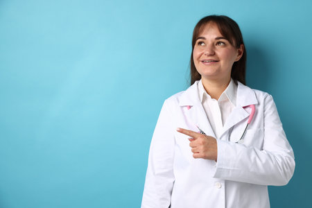 Doctor in medical uniform with stethoscope on light blue background, space for textの写真素材