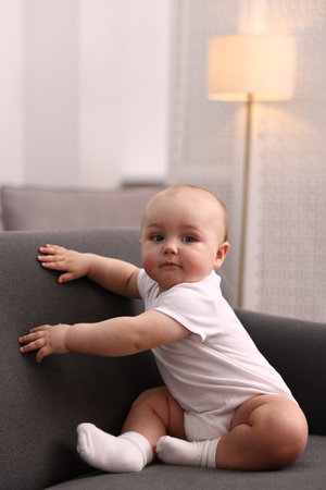 Cute little baby on sofa at homeの写真素材