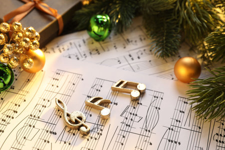 Golden music notes, sheets and Christmas decor on table, closeupの写真素材