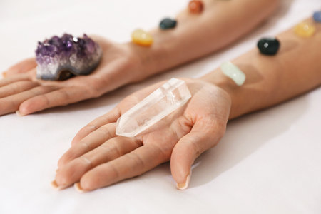 Woman holding crystals to heal or restore her aura on couch, closeupの写真素材