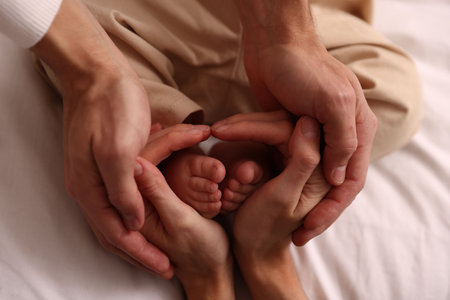 Parents holding their cute baby on bed at home, top viewの写真素材