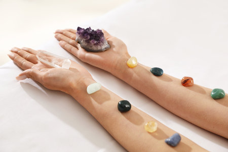 Woman holding crystals to heal or restore her aura on couch, closeupの写真素材