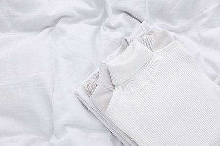 Folded clean laundry on bed, closeup. Space for textの写真素材