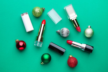 Christmas composition with red lipsticks and baubles on green background, flat layの写真素材
