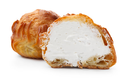 Tasty profiteroles with whipped cream isolated on whiteの写真素材