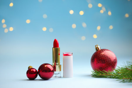 Makeup products and Christmas decor on light blue background with blurred lights, closeup. Bokeh effectの写真素材