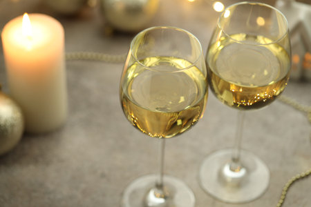 Glasses of white wine and Christmas decor on gray table, closeupの写真素材