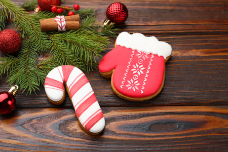 Tasty gingerbread cookies, cinnamon and Christmas decor on wooden table, closeup. Space for textの写真素材
