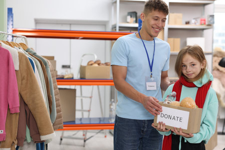 Volunteer giving box of donations to girl in shelter