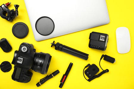 Professional photographer's equipment on yellow background, flat layの写真素材