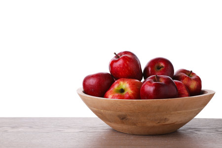 Ripe red apples in bowl on wooden table against white background, closeup. Space for textの写真素材
