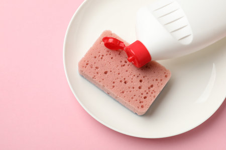 Kitchen sponge, plate and dish soap on pink background, flat layの写真素材