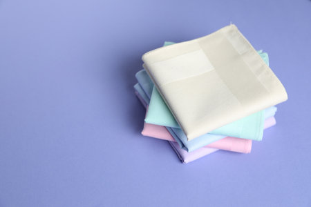 Different pastel color handkerchiefs on lilac background, closeup.の写真素材