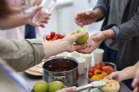 Volunteers giving food to people in shelter, closeupの写真素材
