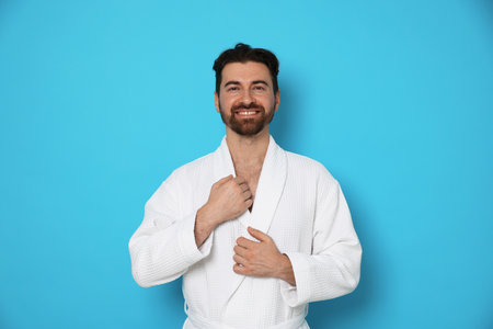 Man in bathrobe on light blue backgroundの写真素材