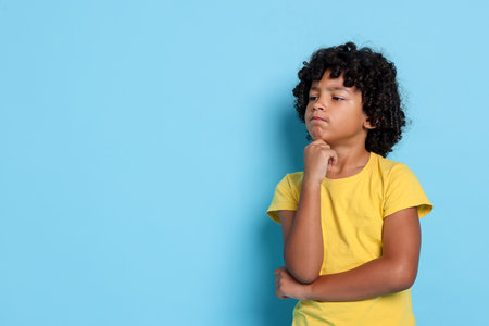 Portrait of little boy on light blue background, space for textの写真素材