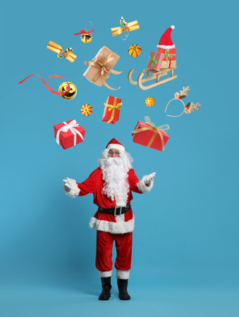 Santa Claus levitating Christmas decor and gift boxes on blue background. Festive magicの写真素材