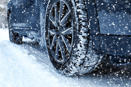 Car on snowy country road, closeup. Adverse weather conditions