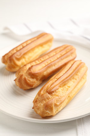 Fresh tasty eclairs on white table, closeupの写真素材