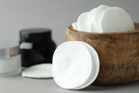 Clean cotton pads and cosmetic products on light gray background, closeupの写真素材