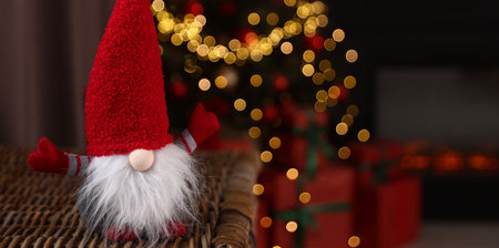 Funny Christmas gnome in decorated room, closeup. Space for textの写真素材