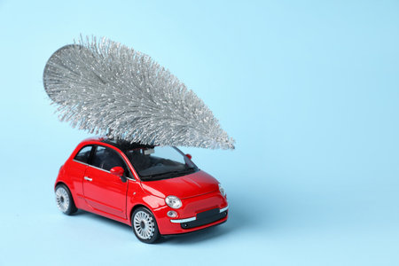 Toy car with tree on light blue background, space for textの写真素材