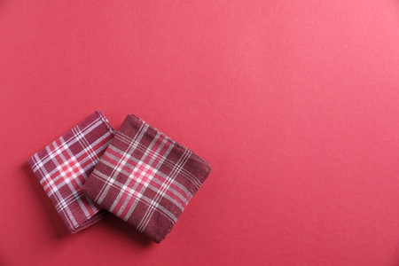 Stylish fabric handkerchiefs on red background, flat lay. Space for text