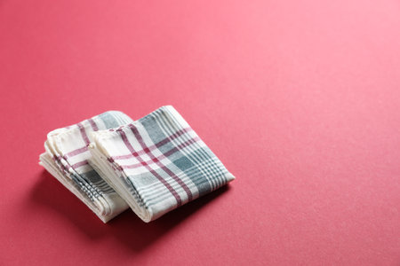Stylish fabric handkerchiefs on red background, closeup. Space for text
