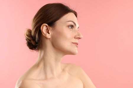 Portrait of beautiful woman on pink background, space for text