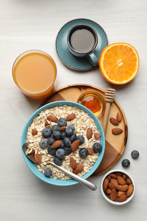 Dry oat flakes, nuts and blueberries served on gray wooden table for breakfast, flat layの写真素材