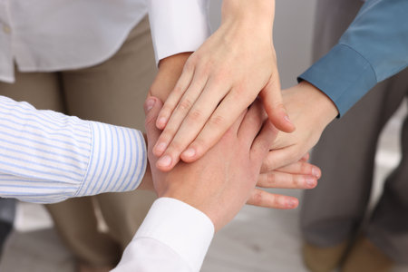 People holding hands together indoors, above view. Team buildingの写真素材