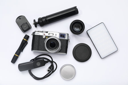 Professional photographer's equipment on white background, flat lay