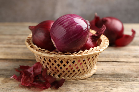 Fresh onion bulbs and peels on wooden table, closeupの写真素材