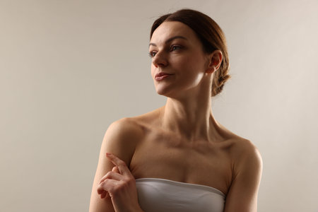 Portrait of beautiful woman on light gray background, space for textの写真素材