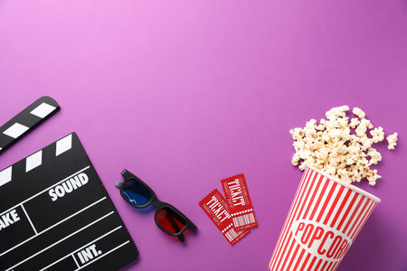 Clapper, 3D glasses, movie tickets and tasty popcorn on violet background, flat lay. Space for textの写真素材