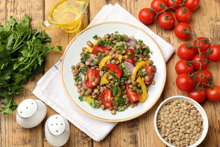 Tasty lentil salad with ingredients on wooden table, flat layの写真素材