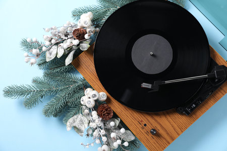 Wooden turntable with vinyl record and Christmas decor on light blue background, flat layの写真素材