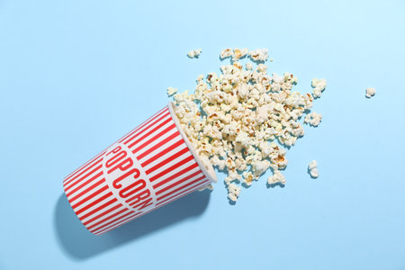 Tasty popcorn in paper cup on light blue background, top viewの写真素材