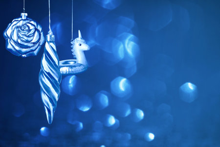 Christmas ornaments against blue background with blurred lights. Happy winter holidaysの写真素材