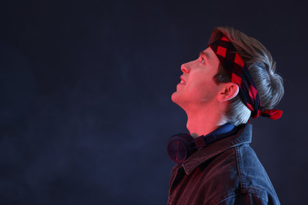 Man wearing headphones on dark background. Space for textの写真素材