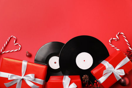 Vinyl records and Christmas decor on red background, flat lay. Space for textの写真素材