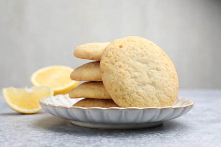 Tasty lemon cookies and fruit slices on gray table, closeupの写真素材
