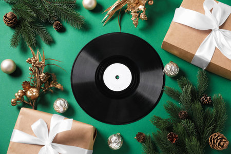 Vinyl record, gift boxes and Christmas decor on green background, flat layの写真素材