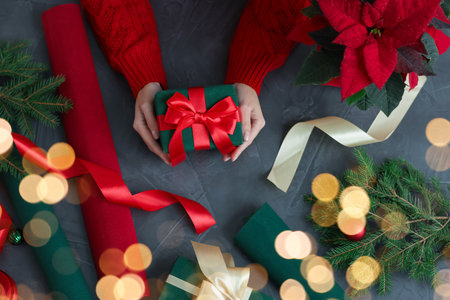 Woman wrapping Christmas gift at gray table, top viewの写真素材