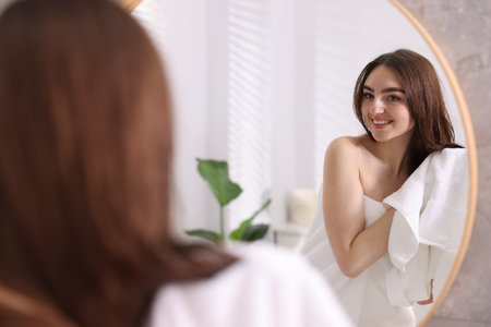 Beautiful woman drying hair with towel in bathroomの写真素材